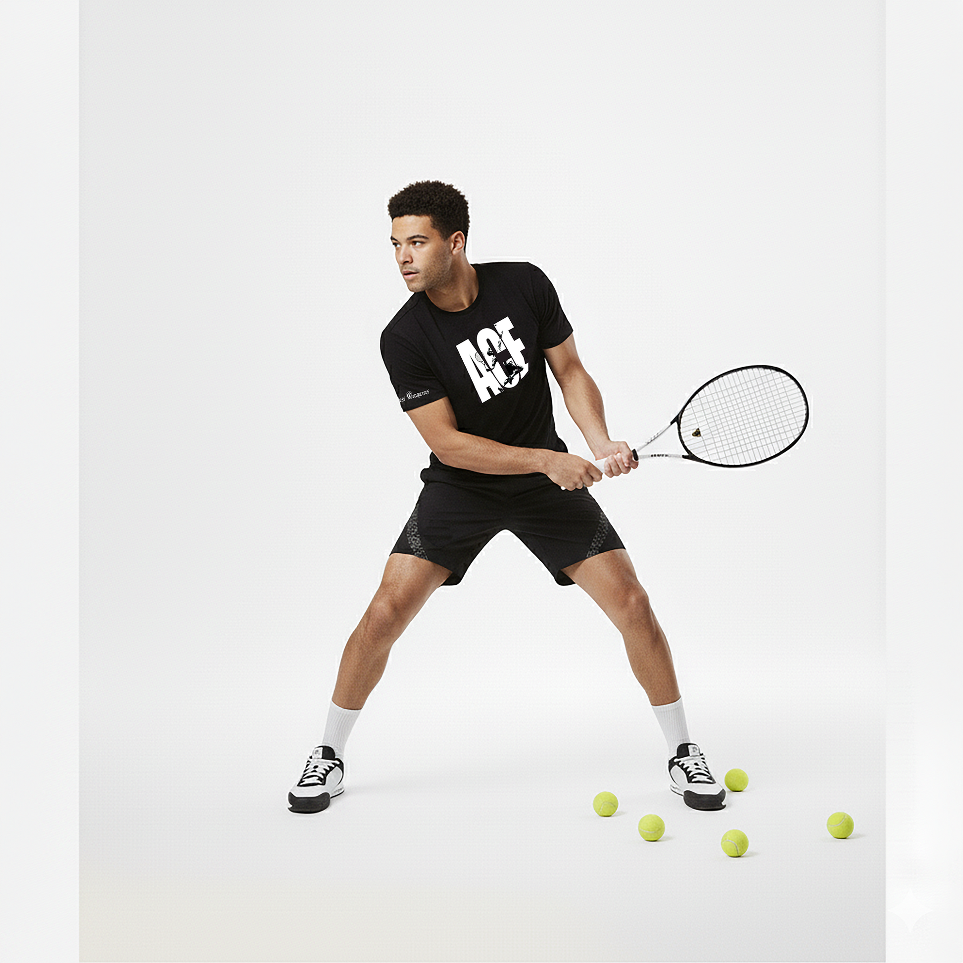 Man in black sports outfit with 'ACE' logo holding a tennis racket on a white background